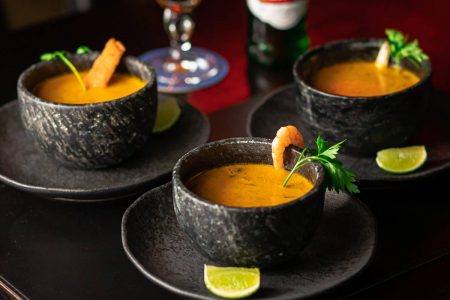 Três cumbucas com caldo de peixe