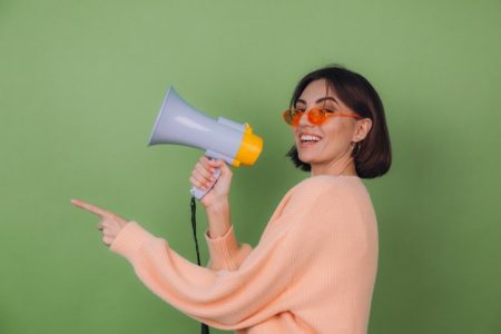 Mulher jovem com megafone na mão