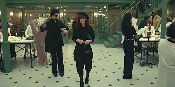 Emma Stone em Cruella com look todo preto e boina