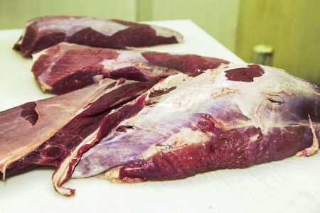 pedaços de carne crua em cima de bancada