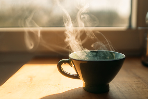 xícara de café ao lado da janela