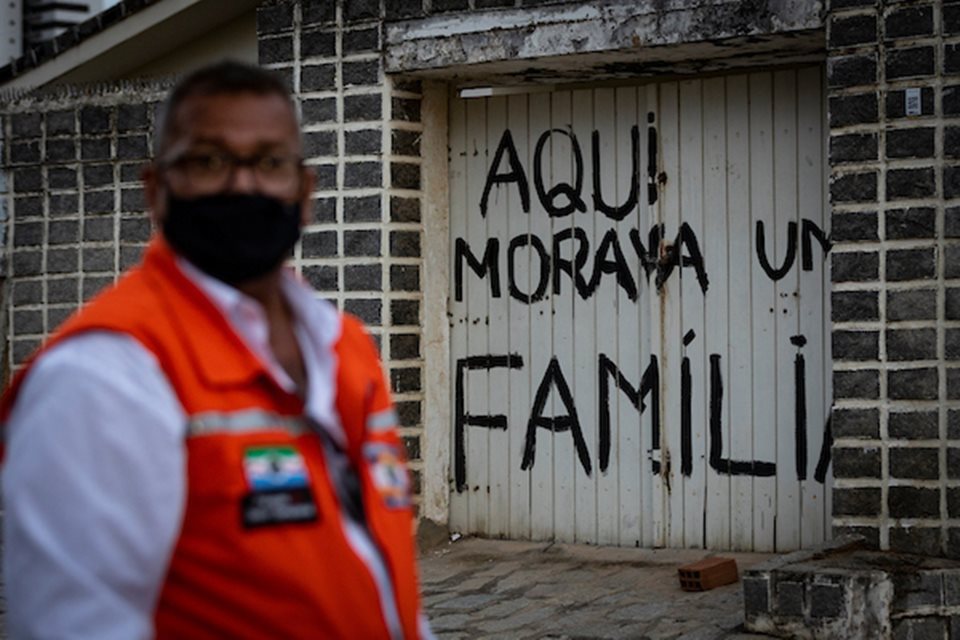 Imagem colorida mostra homem de pé diante de casa abandonada por família em Maceió após terreno afundar por conta de mineração - Metrópoles