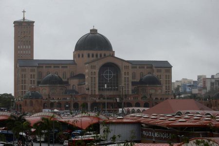 Imagem colorida mostra Basílica de Aparecida, construção de cor ocre, com abóboda no teto, em Aparecida (SP) - Metrópoles