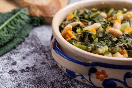 Na imagem, prato de comida com couve verde em cima de uma mesa cinza - Metrópoles