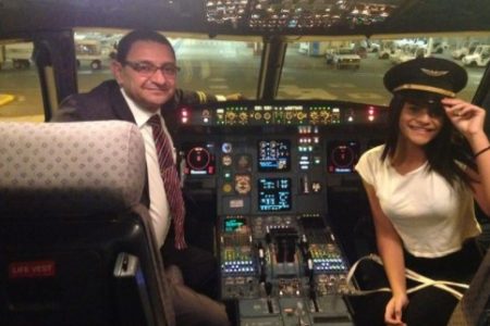 Piloto dentro de avião com menina ao lado