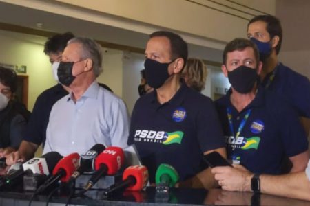 candidatos em frente a microfones