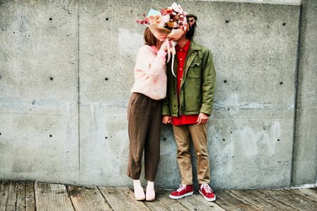 casal se beijando com um buquê de flores cobrindo o rosto