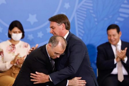 Fotografia colorida com dois homens se abraçando. Do lado esquerdo, o ministro do STF André Mendonça. À direita, presidente Jair Bolsonaro