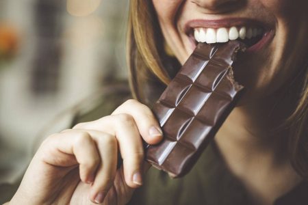 Mulher comendo barra de chocolate