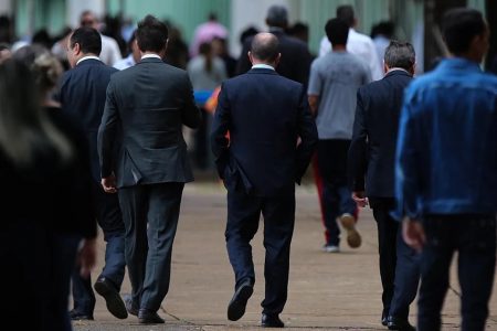 homens de terno de costas caminhando