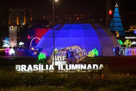 Letreiro do projeto Brasília Iluminada com estrutura luminosa ao fundo
