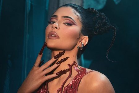 Foto colorida de Kylie Jenner com as unhas vermelhas e sangue falso no pescoço - Metrópoles