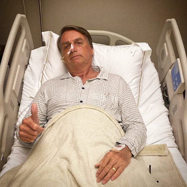 Bolsonaro em cama de hospital com sonda nasogástrica e fazendo sinal de joinha - Metrópoles