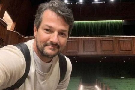 Fotografia colorida de Marcelo com mochila nas costas em selfie