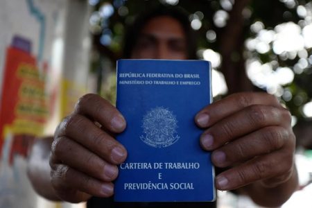 pessoas segurando uma carteira de trabalho