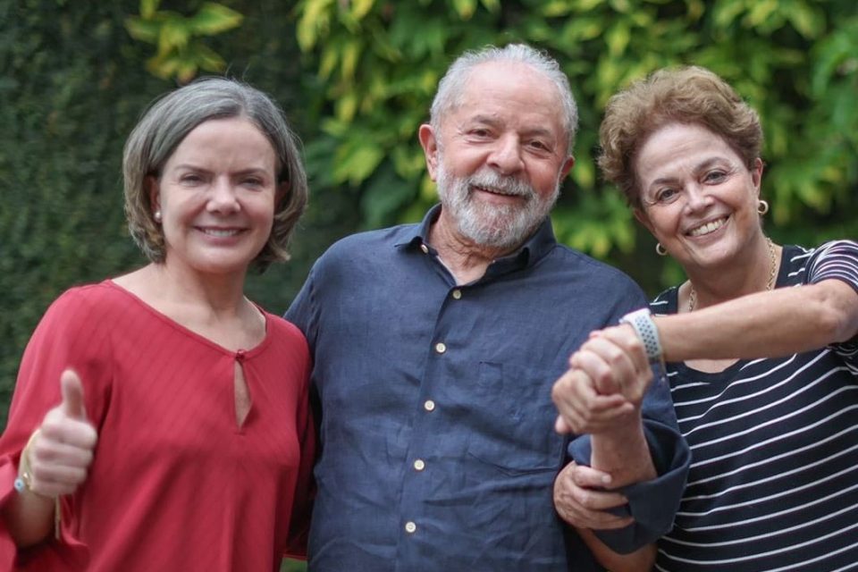 Presidente do PT, Gleisi Hoffmann, em encontro com os ex-presidentes Lula e Dilma Rousseff. Eles sorriem em foto e dão as mãos - Metrópoles