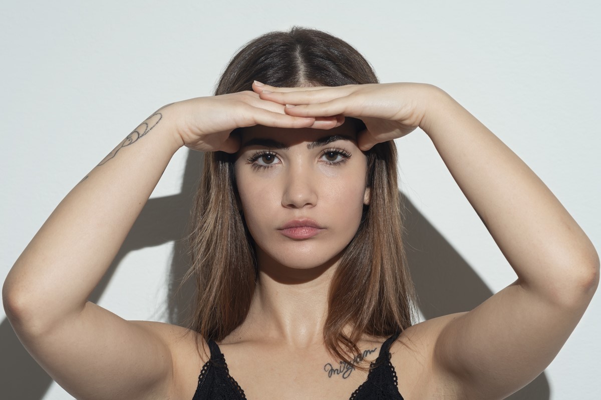 Mulher jovem com as mãos na testa