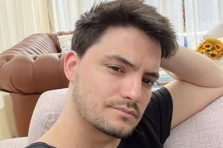 Felipe Neto veste camiseta preta e posa para foto com a mão no rosto-Metrópoles
