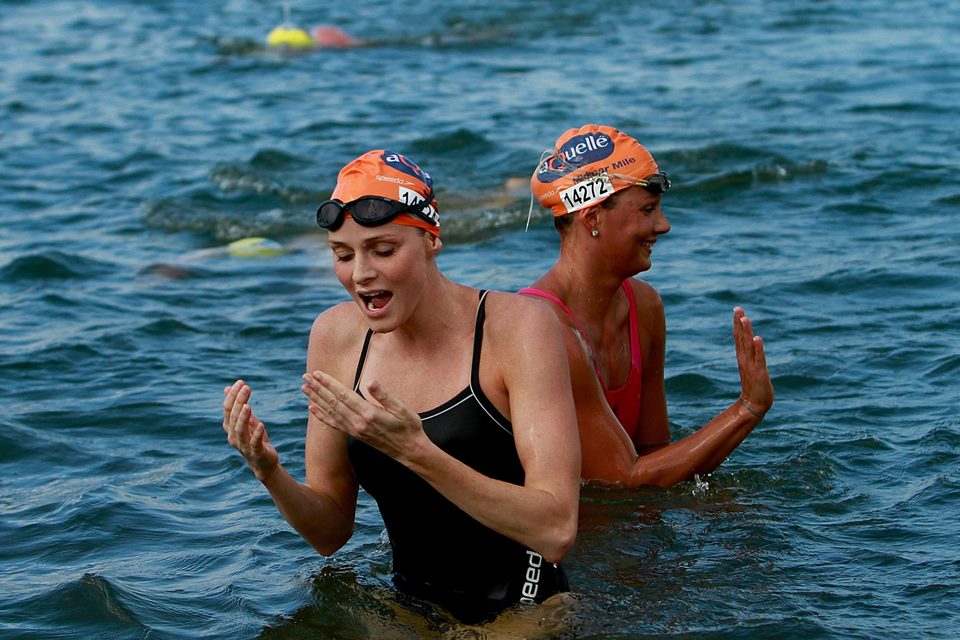 Mulher touca laranja dentro do mar 