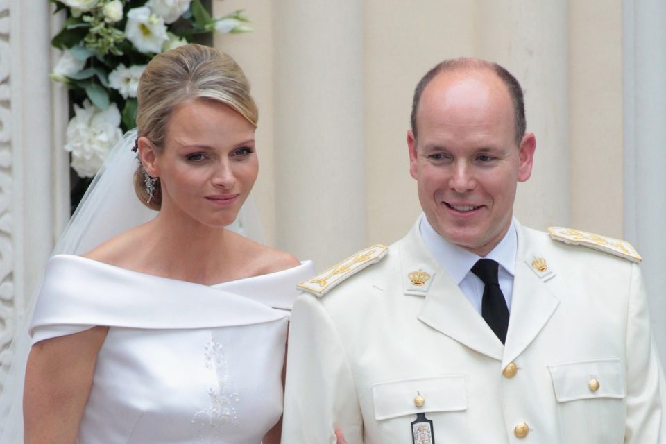Mulher de vestido de noiva ao lado de homem com terno branco