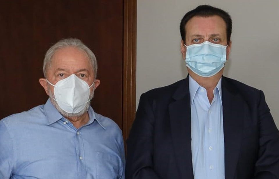 Lula e Gilberto Kassab (PSD) posam para foto. Ambos usam máscara, camisa social e olham sérios para frente, lado a lado - Metrópoles