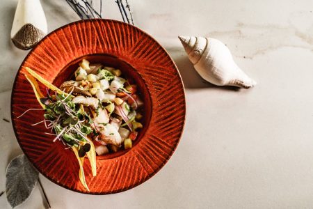 na foto vemos um prato laranja com ceviche