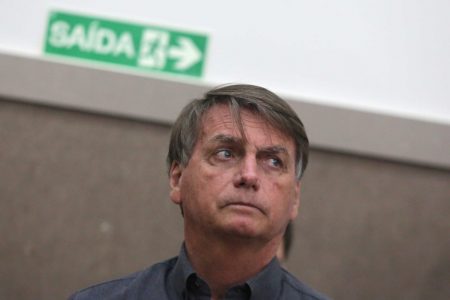 Bolsonaro (PL) em auditório na cidade de Francisco Morato, um dos municípios atingidos pelas chuvas em São Paulo. Ele usa camisa social escura e olha sério para o lado - Metrópoles