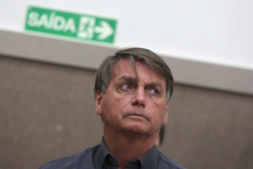 Bolsonaro (PL) em auditório na cidade de Francisco Morato, um dos municípios atingidos pelas chuvas em São Paulo. Ele usa camisa social escura e olha sério para o lado - Metrópoles