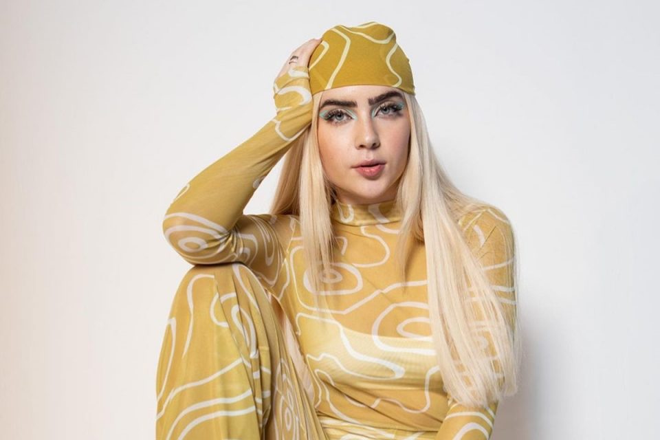 Jade Picon com o cabelo louro e roupa transparente