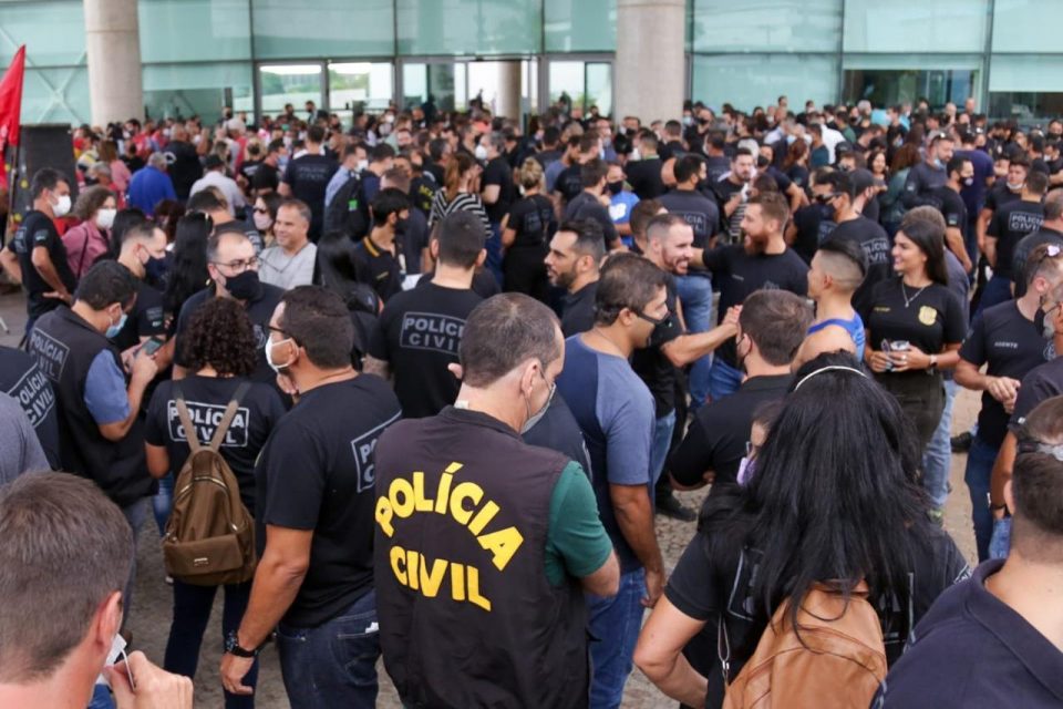 Policiais civis de uniforme amontoados