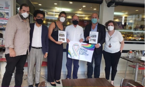 O ex-governador Geraldo Alckmin segura uma bandeira da Aliança Nacional LGBTI+ e posa para foto ao lado de integrantes do grupo