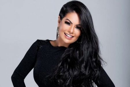 Paulinha Abelho posa para foto vestida de roupa preta com mangas e mão na cintura-Metrópoles