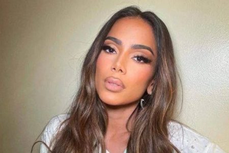 Cantora Anitta posando para foto. Ela usa roupa clara e olha seriamente para a camera para a câmera - Metrópoles