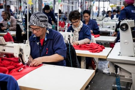 Na imagem com cor, trabalhadores da indústria da moda