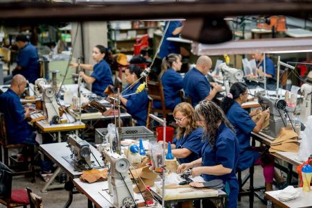 Na imagem com cor, trabalhadores da indústria da moda