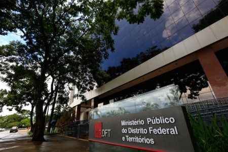 Prédio com placa e árvore ao lado