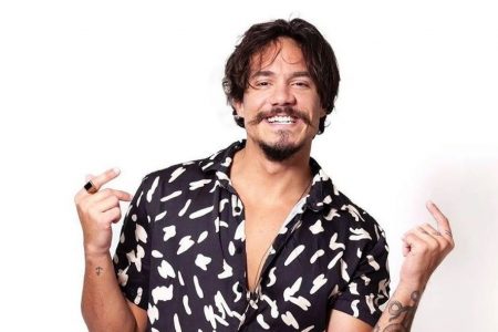 Elieser usa camiseta preta estampada. Ele tem cabelos e barba pretos - Metrópoles