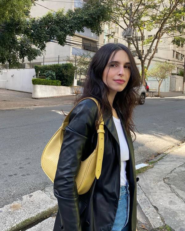 mulher branca usa bolsa amarela e jaqueta preta