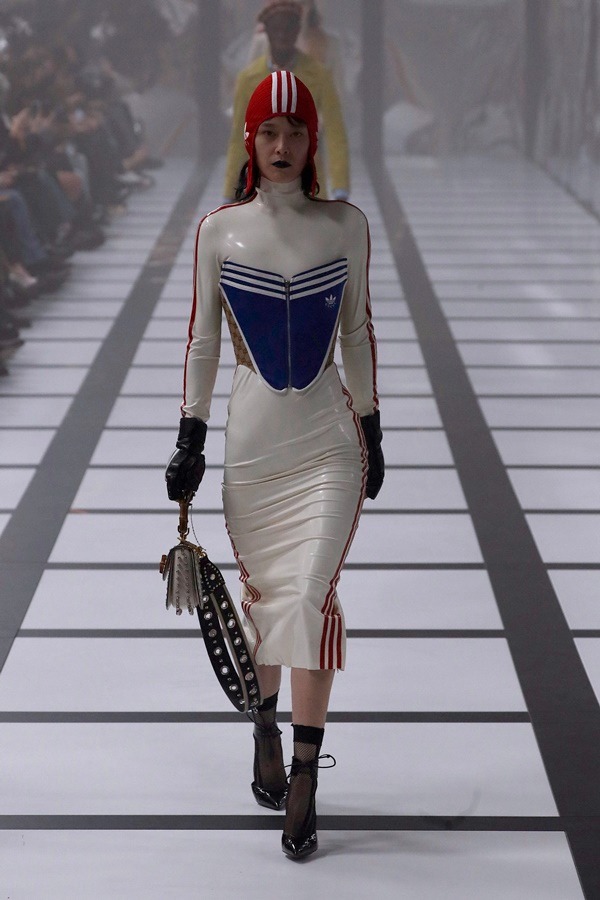 Na imagem com cor, modelo desfila com peças da parceria entre a Gucci e Adidas