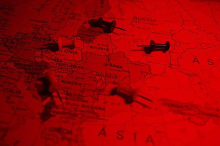 Imagem ilustrativa de mapa da Eurásia, mostrando Rússia e Ucrânia com alfinetes jogados por cima, num filtro vermelho - Metrópoles