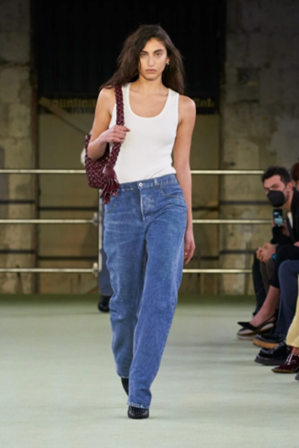 Na imagem com cor, modelo desfila com blusa regata branca da nova coleção de Bottega Veneta