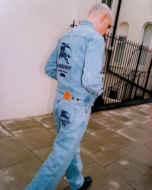 Homem branco usando peças jeans andando na rua