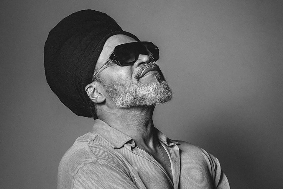 Foto em preto e branco de Carlinhos Brown. O cantor usa um óculos escuro - Metrópoles