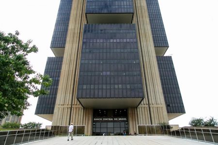 Homem caminha em frente a entrada do prédio do Banco Central em Brasília