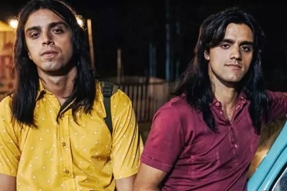 Rodrigo Simas e Felipe Simas interpretam a dupla Chitãozinho & Xororó na minissérie As Aventuras de José & Durval. Enquanto um dos irmãos está de camisa amarelo, o outro veste uma camisa vermelha. Eles estão com cabelo grande e preto - Metrópoles