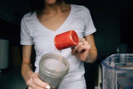 Imagem mostra mulher colocando whey protein em coqueteleira- Metrópoles