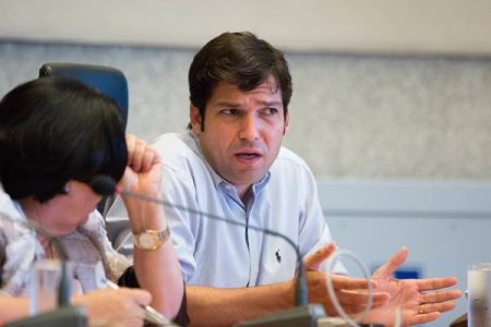 Homem e mulher conversam apoiados em mesa