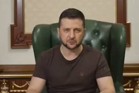 Homem sentado de blusa marrom em uma cadeira de escritório, presidente da ucrânia Volodymyr Zelensky