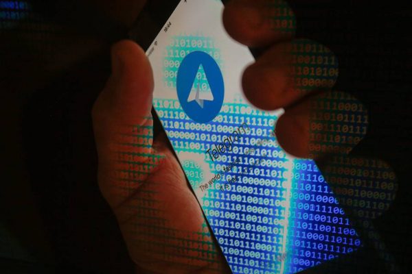 mão segura celular com logo do Telegram