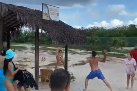 pessoas com roupas de banho vandalizam barraca de praia